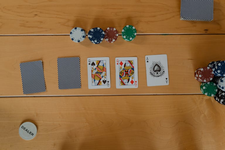 한게임 포커 A poker game setup showing cards and chips on a wooden table, ready to play.